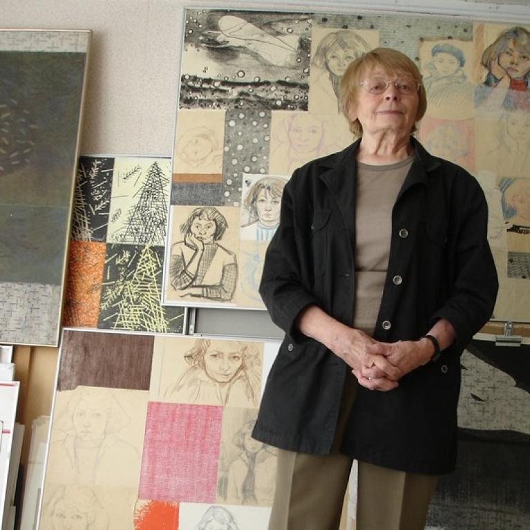blond short-haired white woman of late age standing in her art studio