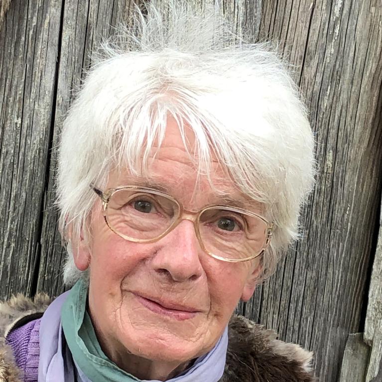 headshot of an elderly woman with short gray hair wearing glasses