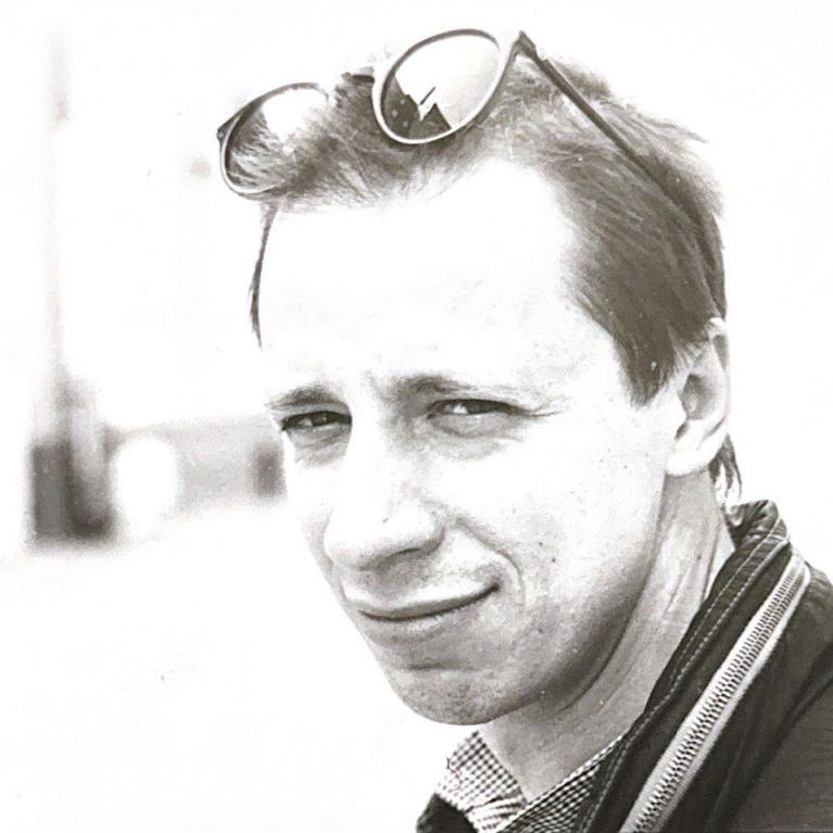 young man with short hair and sunglasses over his head