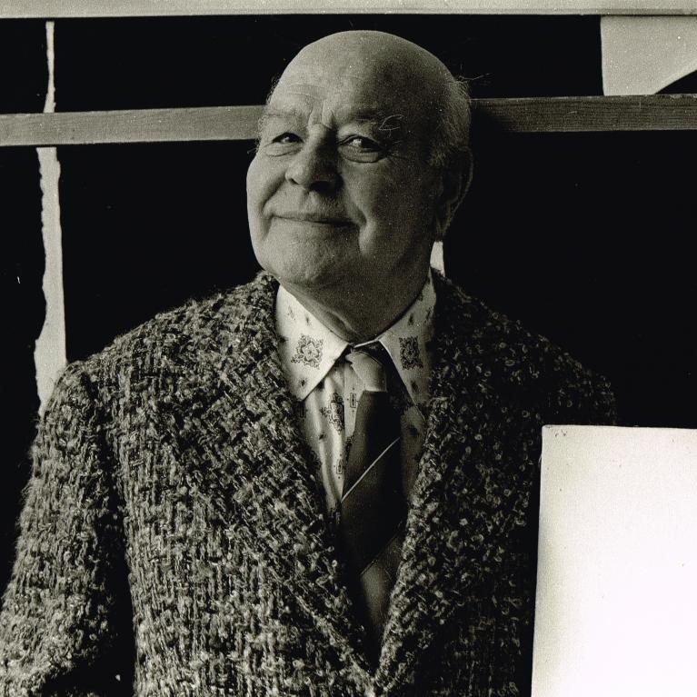 a smiling older man in thick wool suit