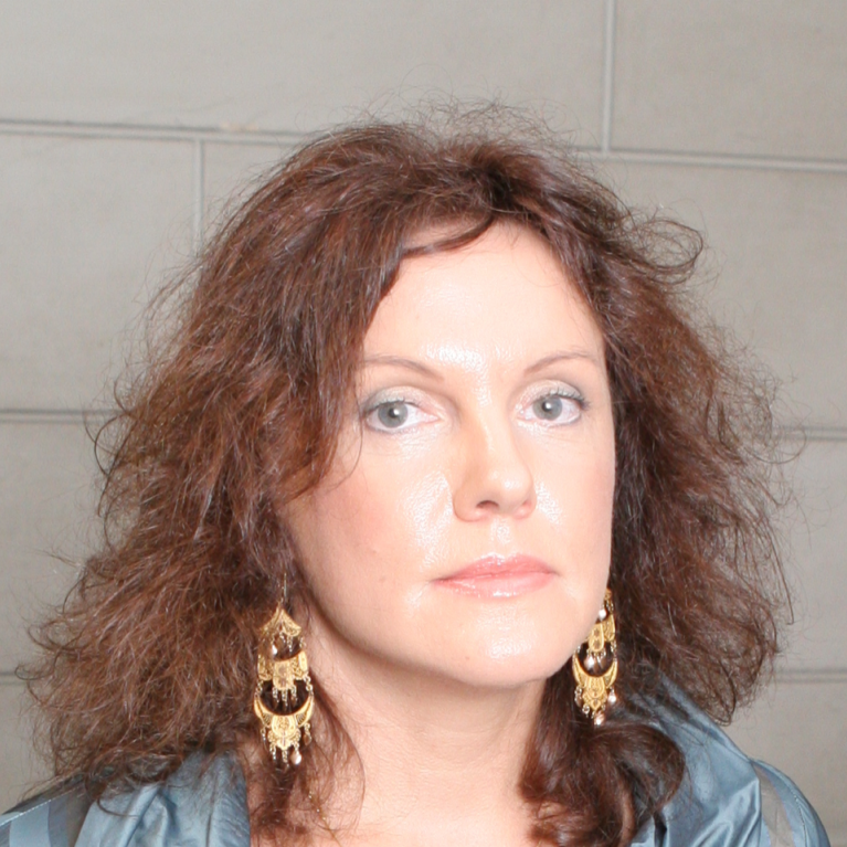 middle-aged woman with long wavy hair and chandelier earrings 