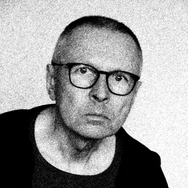 middle aged man wearing glasses staring into the camera with intense gaze