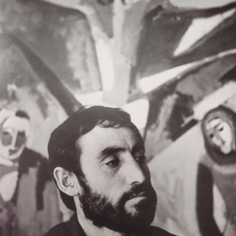 A black and white photograph showing a person in front of a mural or painting depicting a crucifixion scene with Jesus on the cross and two other figures on either side.