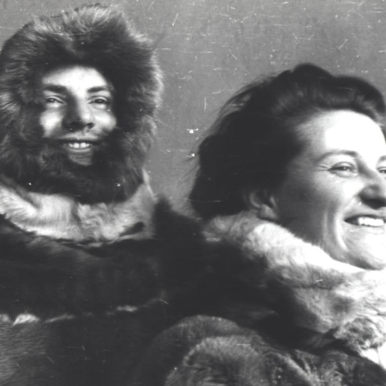 black and white photograph of a young smiling couple wearing North indigenous style fur coats