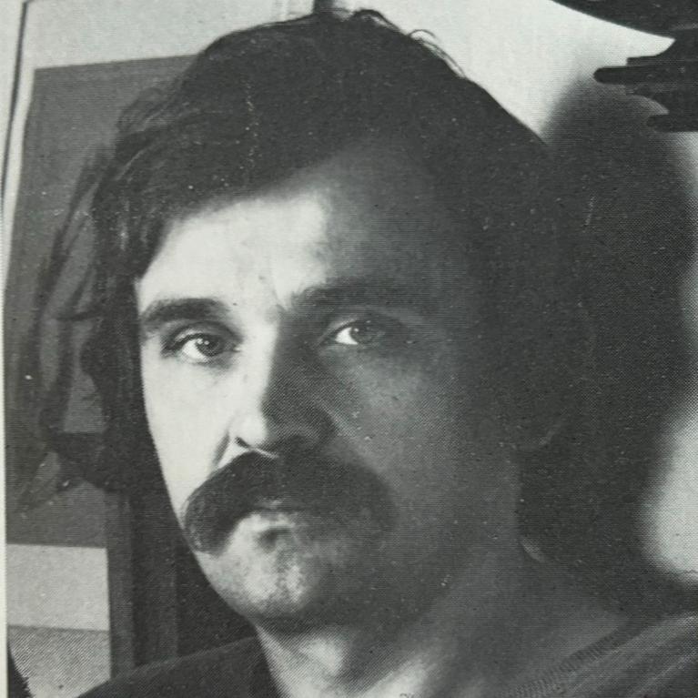 black and white photo of a man with moustache looking straight into camera
