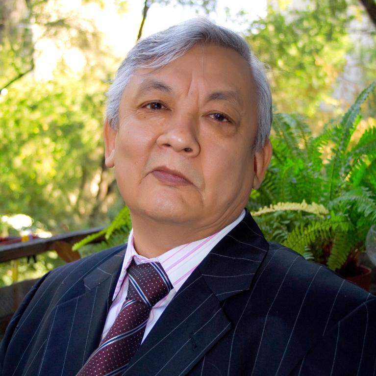 photo portrait of a man in a suit at the background of greenery